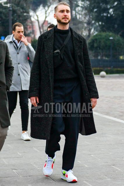 Men's coordinate and outfit with black herringbone chester coat, dark gray solid color sweater, dark gray solid color jogger pants/ribbed pants, Nike white low-cut sneakers, and black solid color body bag.