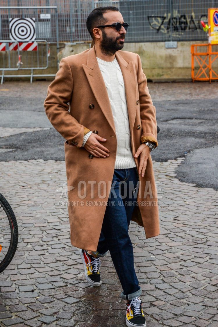 Men's coordinate and outfit with solid color sunglasses, solid color beige chester coat, solid color white sweater, solid color blue denim/jeans, and Vans Old School black low-cut sneakers.