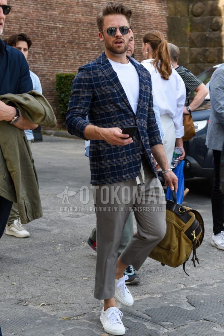 Men's coordinate and outfit with plain silver sunglasses, navy check tailored jacket, plain white t-shirt, plain gray easy pants, and white low-cut sneakers.