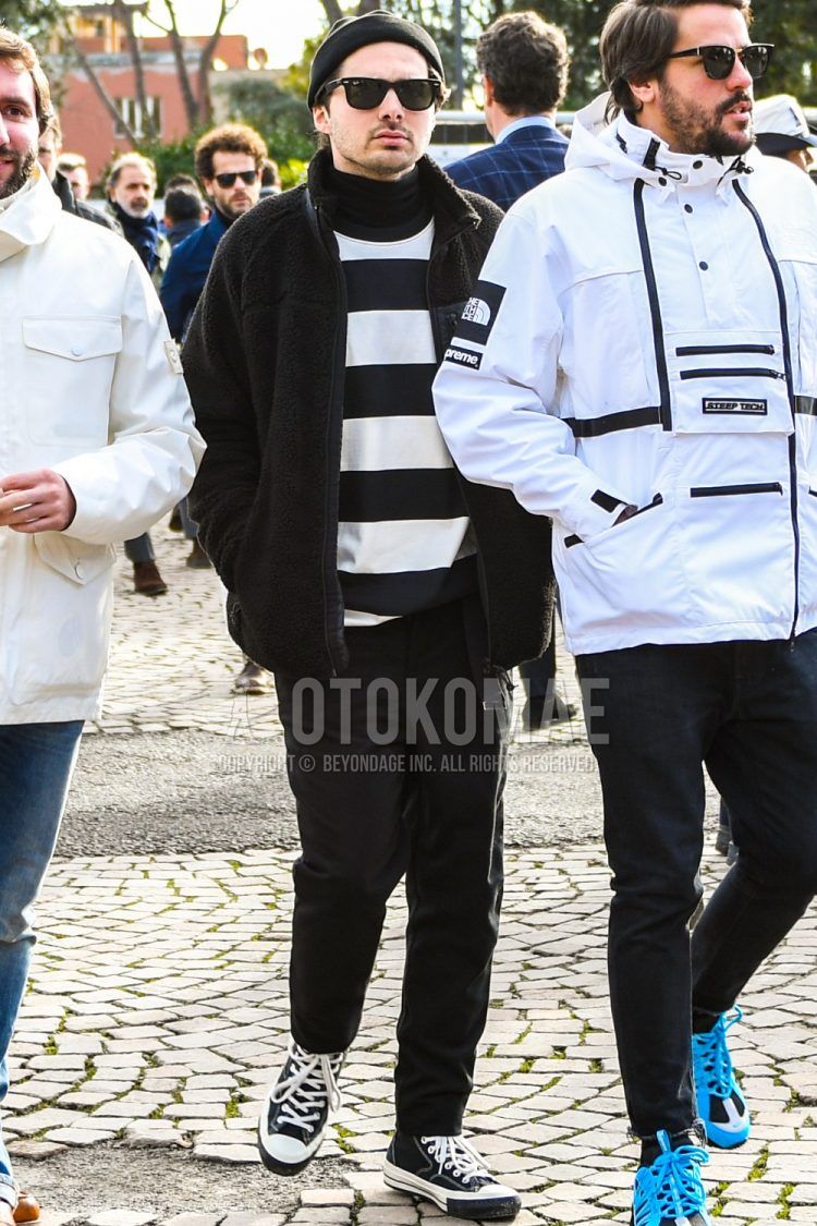 Men's coordinate and outfit with plain black knit cap, plain sunglasses, plain black fleece jacket, black and white striped sweatshirt, plain black turtleneck knit, plain black bottoms, and white and black high-cut sneakers.