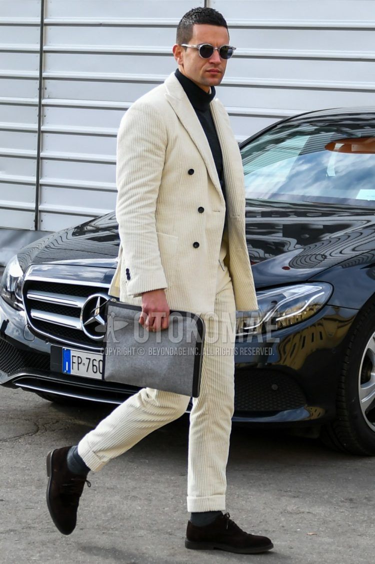 Men's coordinate and outfit with solid color sunglasses, solid color turtleneck knit, dark gray solid color socks, brown suede shoes leather shoes, solid color gray briefcase/handbag, and solid color white suit.