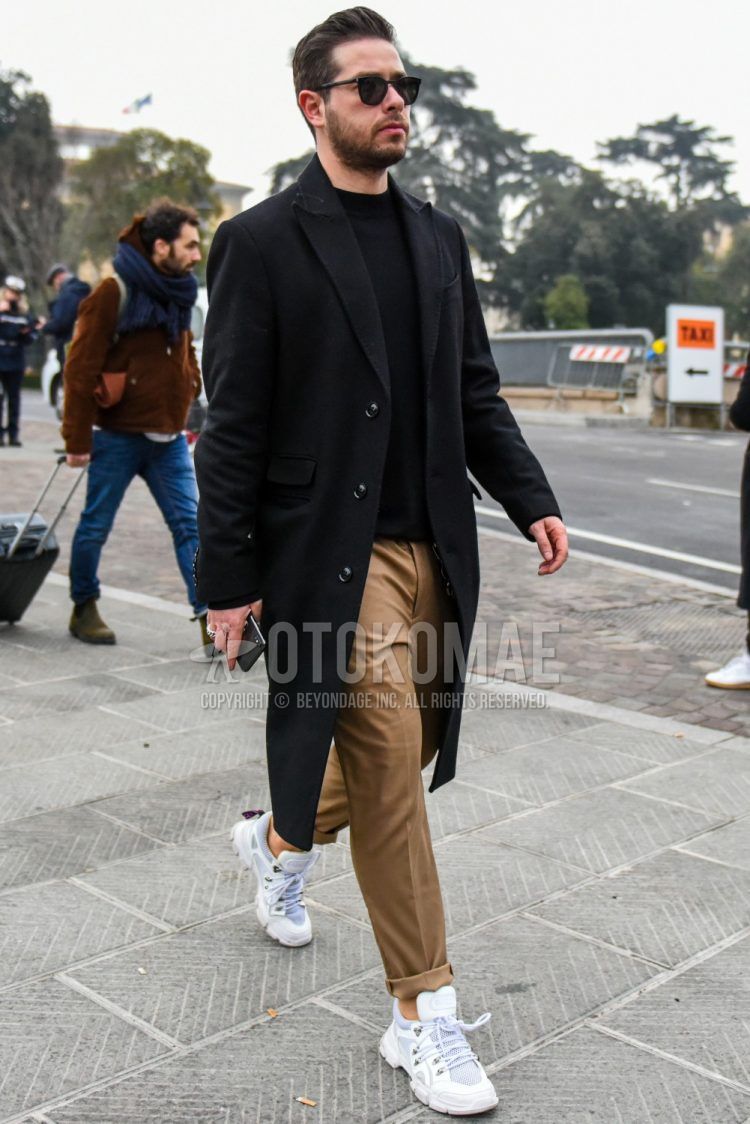 Men's coordinate and outfit with plain sunglasses, plain black chester coat, plain black sweater, plain brown cotton pants, and white low-cut sneakers.
