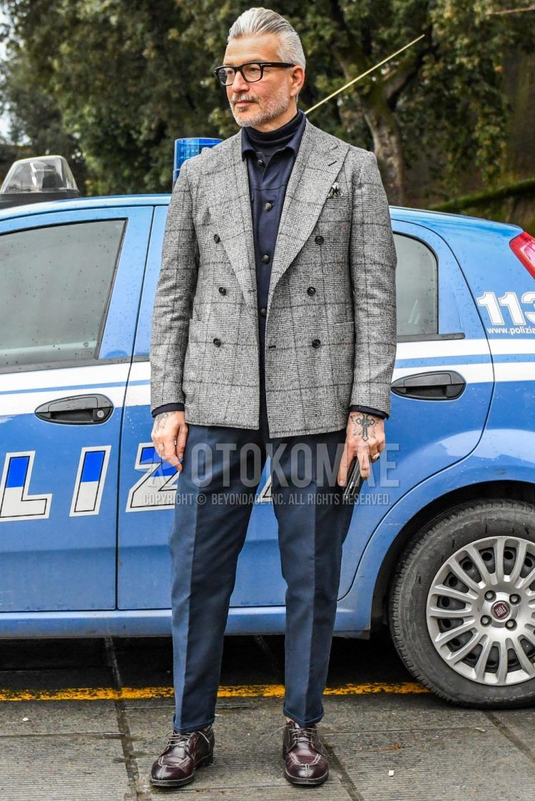 Men's coordination and outfit with plain glasses, gray checked tailored jacket, plain navy shirt jacket, plain navy turtleneck knit, plain navy cotton pants, and brown U-tip leather shoes.