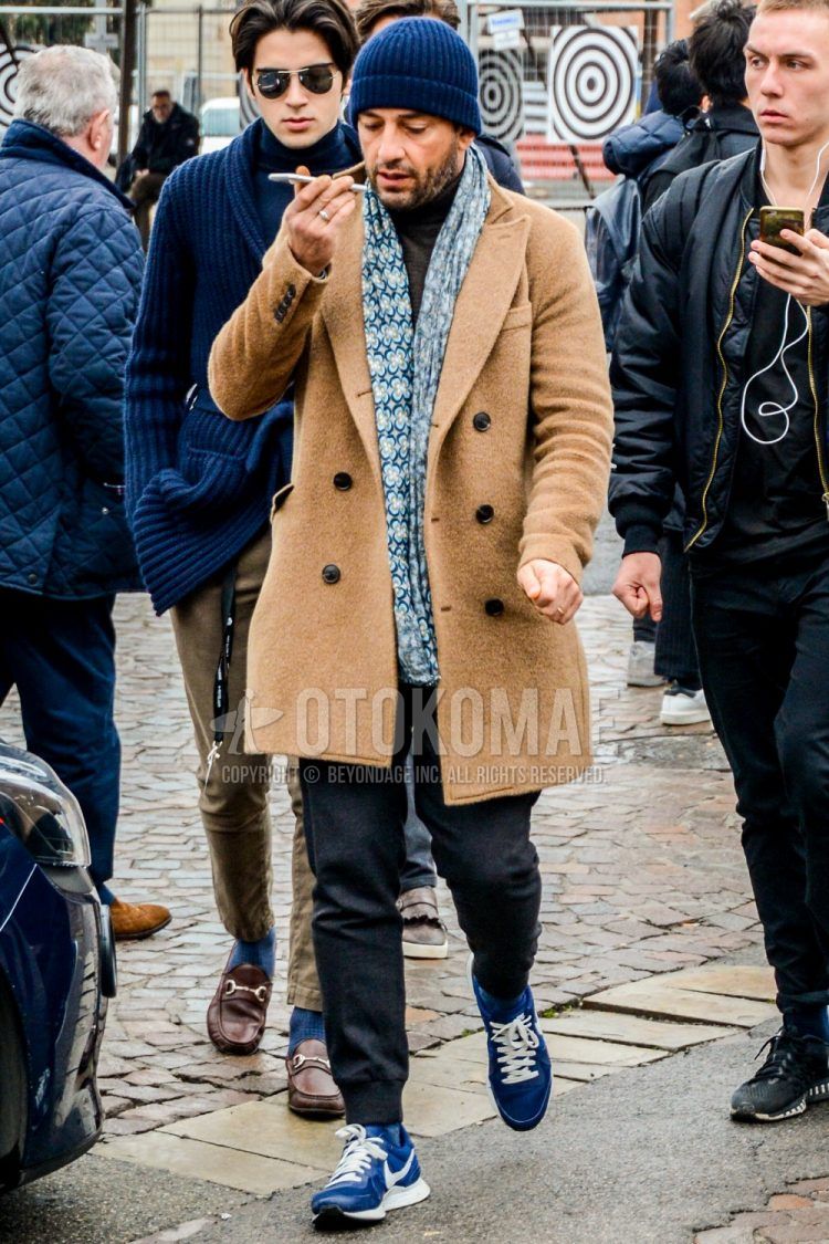 Men's coordinate and outfit with plain knit cap, multi-colored scarf/stall, plain beige chester coat, plain gray sweatpants, plain jogger pants/ribbed pants, and blue low-cut sneakers.