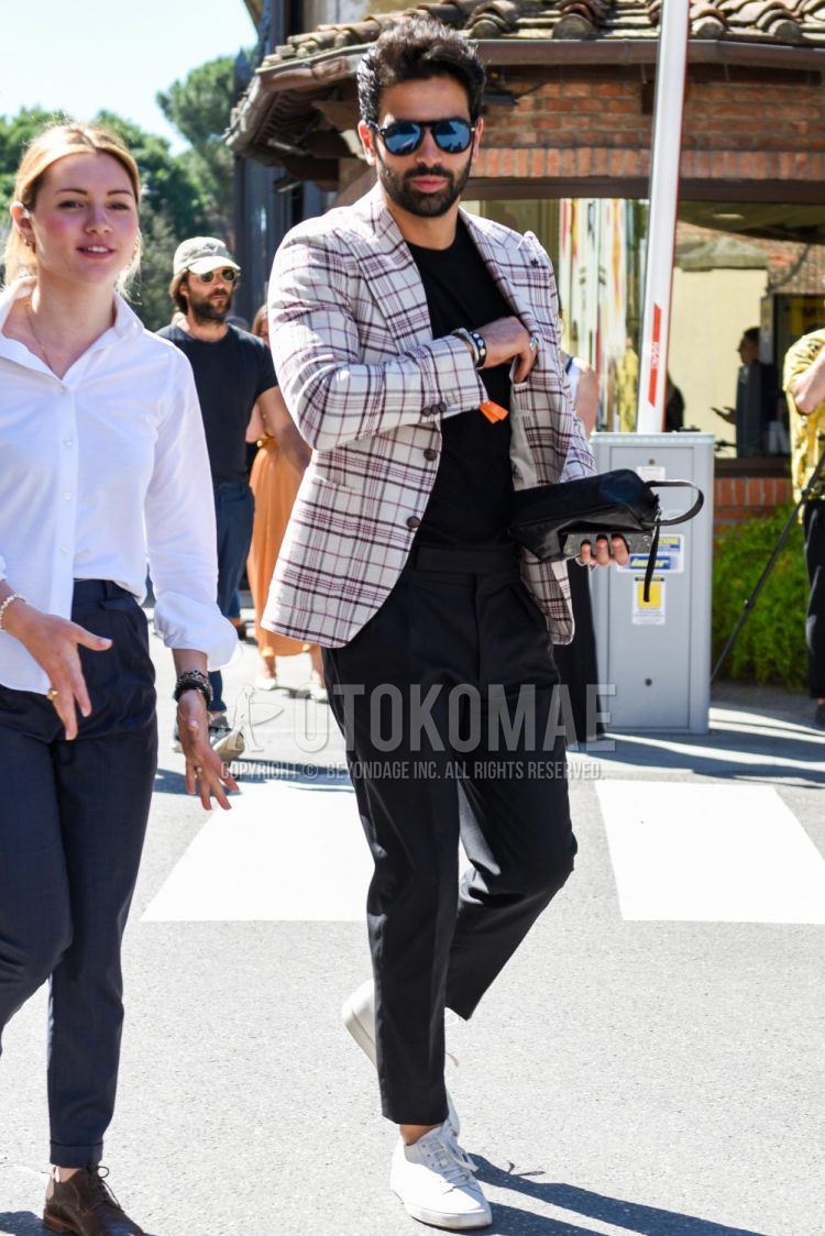 Men's coordinate and outfit with plain black sunglasses, white checked tailored jacket, plain black t-shirt, plain gray slacks, and white low-cut sneakers.