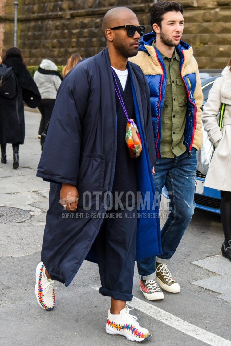 Men's coordinate and outfit with plain sunglasses, plain navy down jacket, plain black cardigan, plain white t-shirt, plain black cotton pants, Nike white low-cut sneakers, and multi-colored bag sacoche.