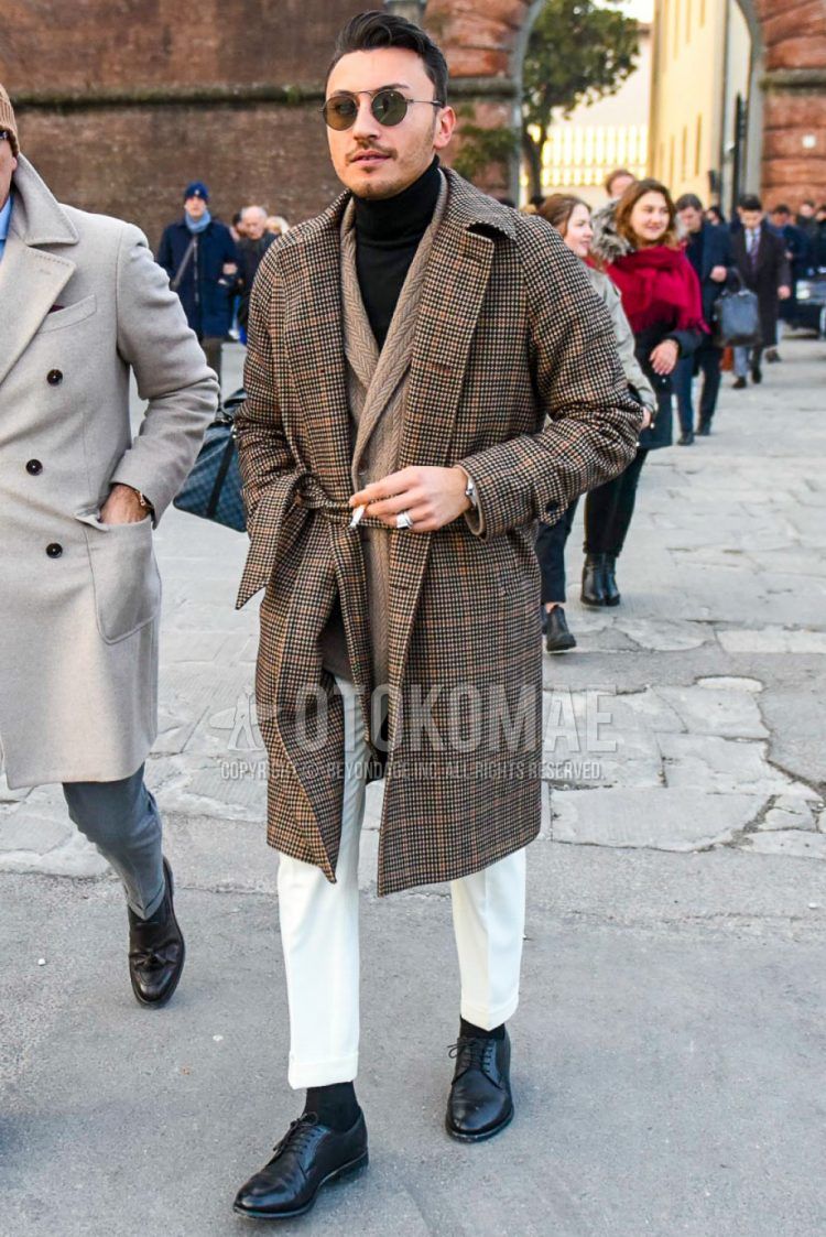 Men's coordinate and outfit with plain sunglasses, brown checked belted coat, plain brown cardigan, plain black turtleneck knit, plain white slacks, plain black socks, and black plain-toe leather shoes.