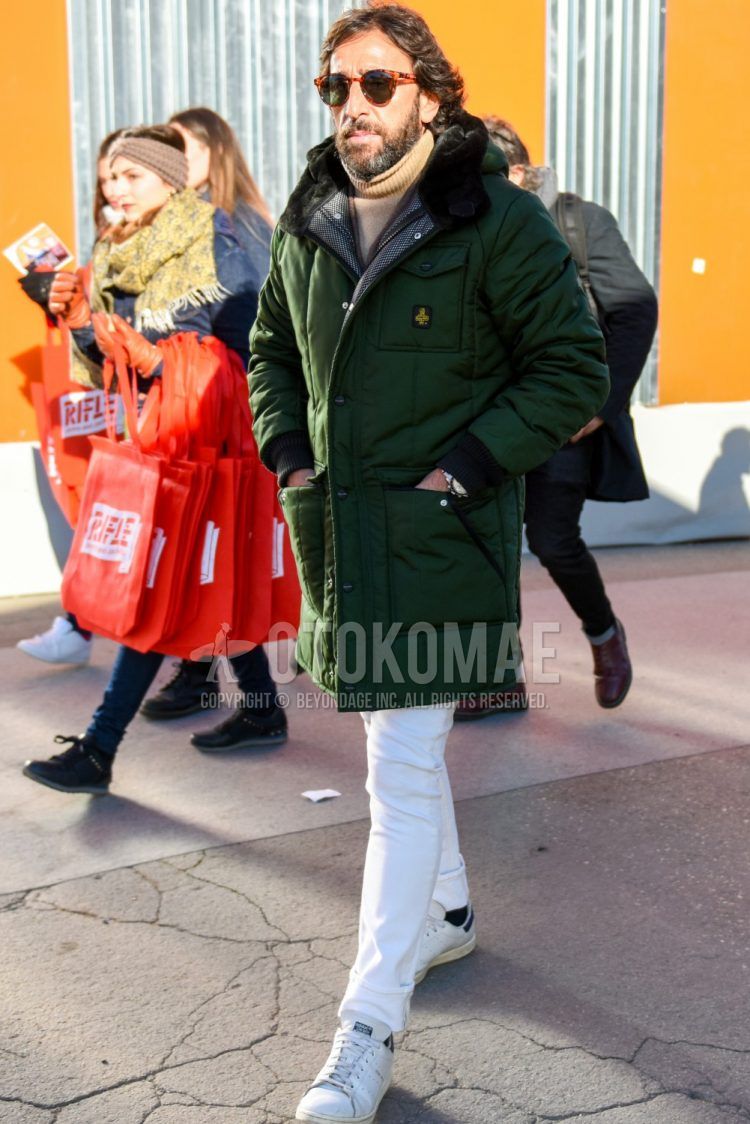Men's coordinate and outfit with solid color sunglasses, solid color green down jacket, solid color brown turtleneck knit, solid color white cotton pants, and white low-cut Adidas Stan Smith sneakers.