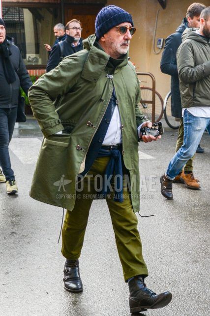 Men's coordinate and outfit with plain navy knit cap, plain sunglasses, plain olive green hooded coat, plain white shirt, plain olive green cotton pants, and black boots.