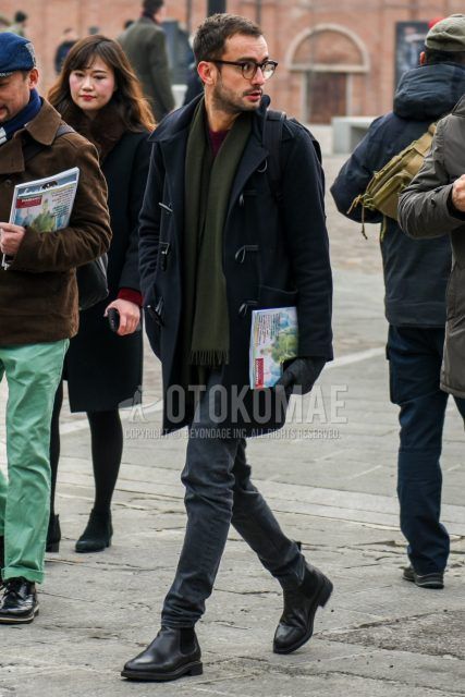 Men's winter/autumn coordinate and outfit with plain black glasses, plain olive green scarf/stall, plain black duffle coat, plain red sweater, plain gray denim/jeans, and black side gore boots.