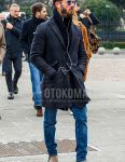 Men's coordinate and outfit with solid color sunglasses, dark gray solid color chester coat, solid color black cardigan, solid color blue denim/jeans, and brown side gore boots.