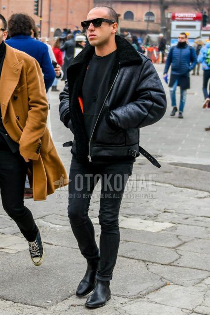 Men's coordinate and outfit with solid color sunglasses, solid color black leather jacket (other than rider's), solid color black sweater, solid color black denim/jeans, and black side gore boots.