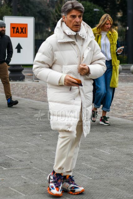 Men's coordinate and outfit with plain white down jacket, plain white inner down, plain white slacks and Balenciaga track trainers with multi-colored low-cut sneakers.
