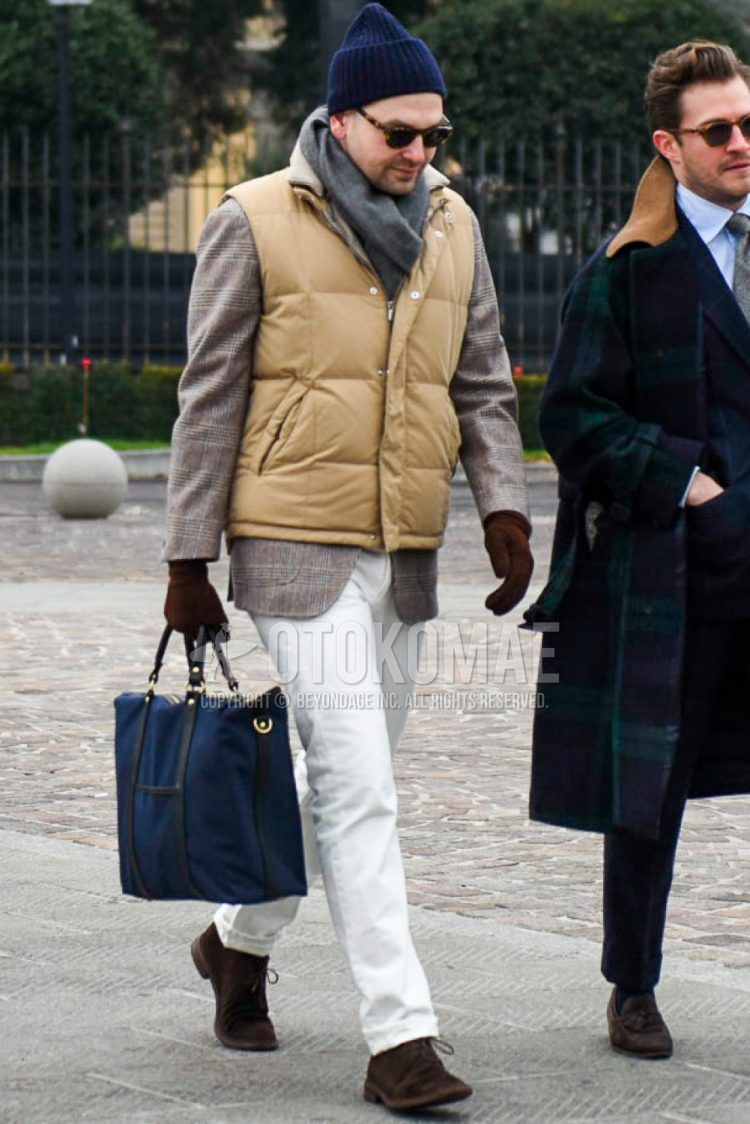 Solid navy knit cap, brown tortoiseshell sunglasses, solid gray scarf/stall, solid beige down jacket, beige checked tailored jacket, solid white denim/jeans, suede brown chukka boots, solid navy briefcase/ Men's coordinate/outfit with handbag.