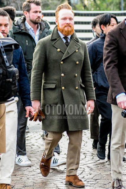 Winter men's outfit with olive green solid color Ulster coat, white solid color shirt, beige solid color slacks, suede brown monk shoes leather shoes, and black solid color tie.
