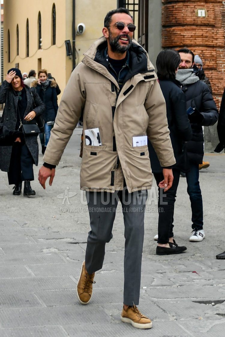 Men's coordinate and outfit with plain silver sunglasses, plain beige down jacket, plain blue denim jacket, plain black sweater, plain gray slacks, and beige low-cut sneakers.
