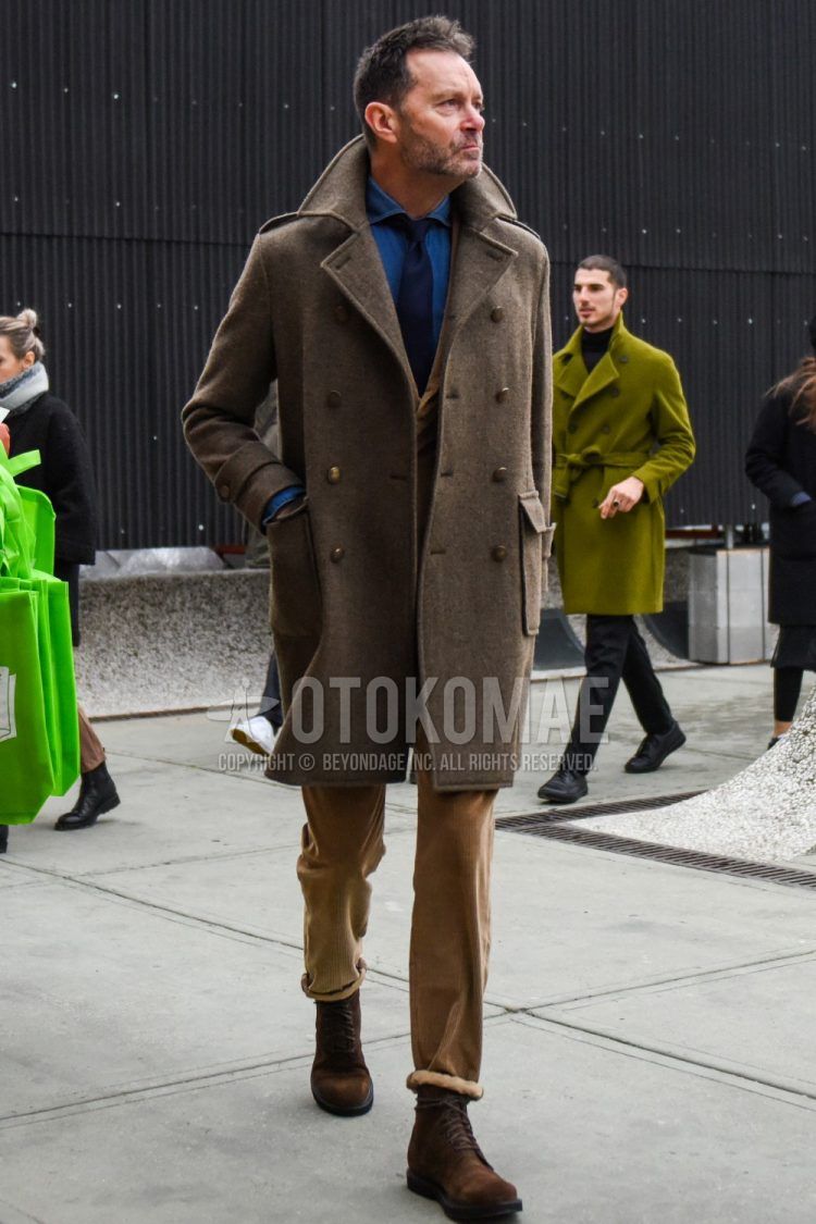 Men's winter coordinate/outfit with solid beige Ulster coat, solid beige tailored jacket, solid blue denim/chambray shirt, solid beige winter pants (corduroy,velour), suede brown boots, solid navy tie.