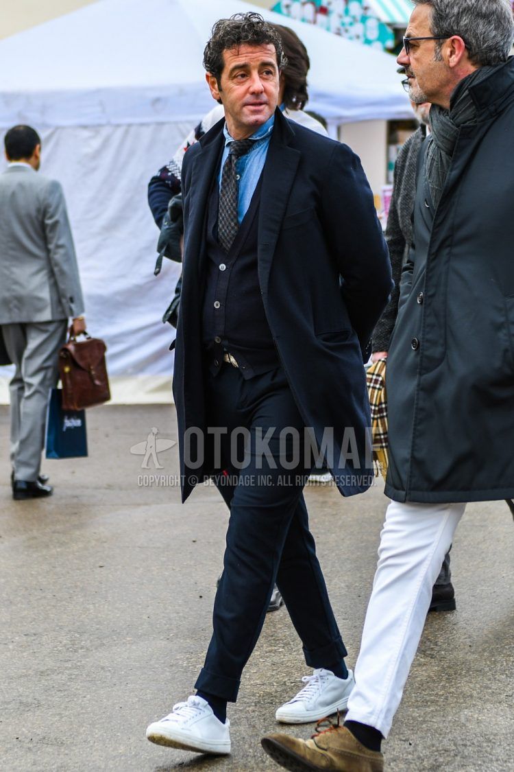 Men's coordinate and outfit with plain navy chester coat, plain navy cardigan, plain light blue denim/chambray shirt, plain navy slacks, plain navy socks, white low-cut sneakers, and dark gray check tie.