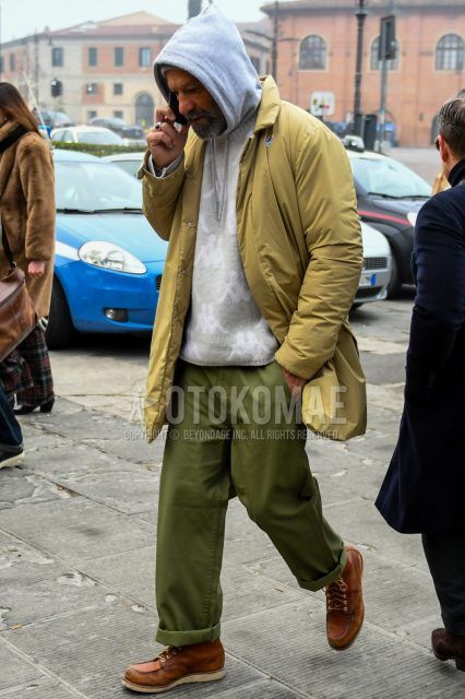 Men's coordinate and outfit with solid beige down jacket, solid gray sweater, solid gray hoodie, solid olive green cotton pants, and brown work boots.
