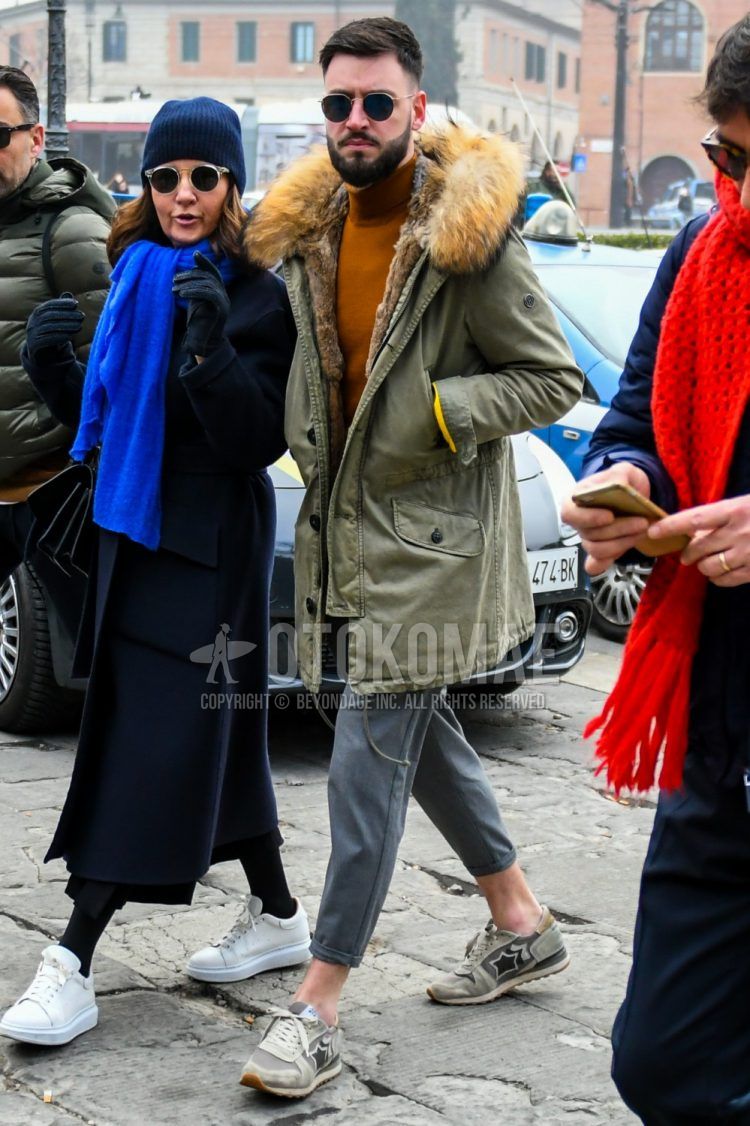 Men's coordinate and outfit with solid color sunglasses, solid green down jacket, solid brown turtleneck knit, solid gray cotton pants, and gray low-cut sneakers by Atlantic Stars.