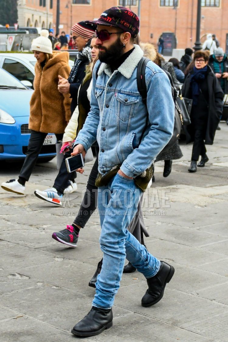 Men's coordinate and outfit with red graphic baseball cap, solid light blue denim jacket, solid light blue denim/jeans, and black side gore boots.