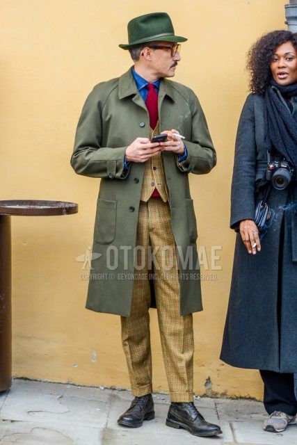 Men's coordinate and outfit with solid hat, solid color glasses, olive green solid color stainless steel coat, light blue solid color denim/chambray shirt, black wingtip leather shoes, beige check three-piece suit, and red solid color tie.