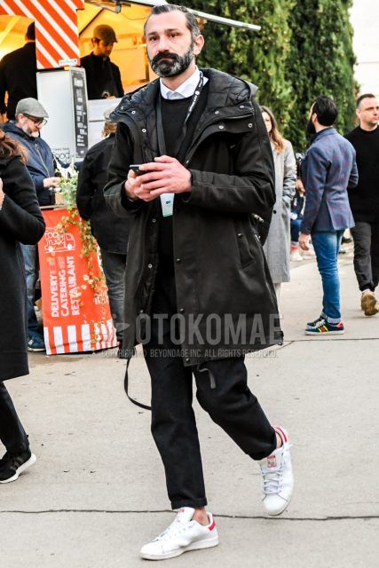 Men's coordinate and outfit with plain black hooded coat, plain black sweater, plain white shirt, plain black bottoms, and Adidas Stan Smith white low-cut sneakers.