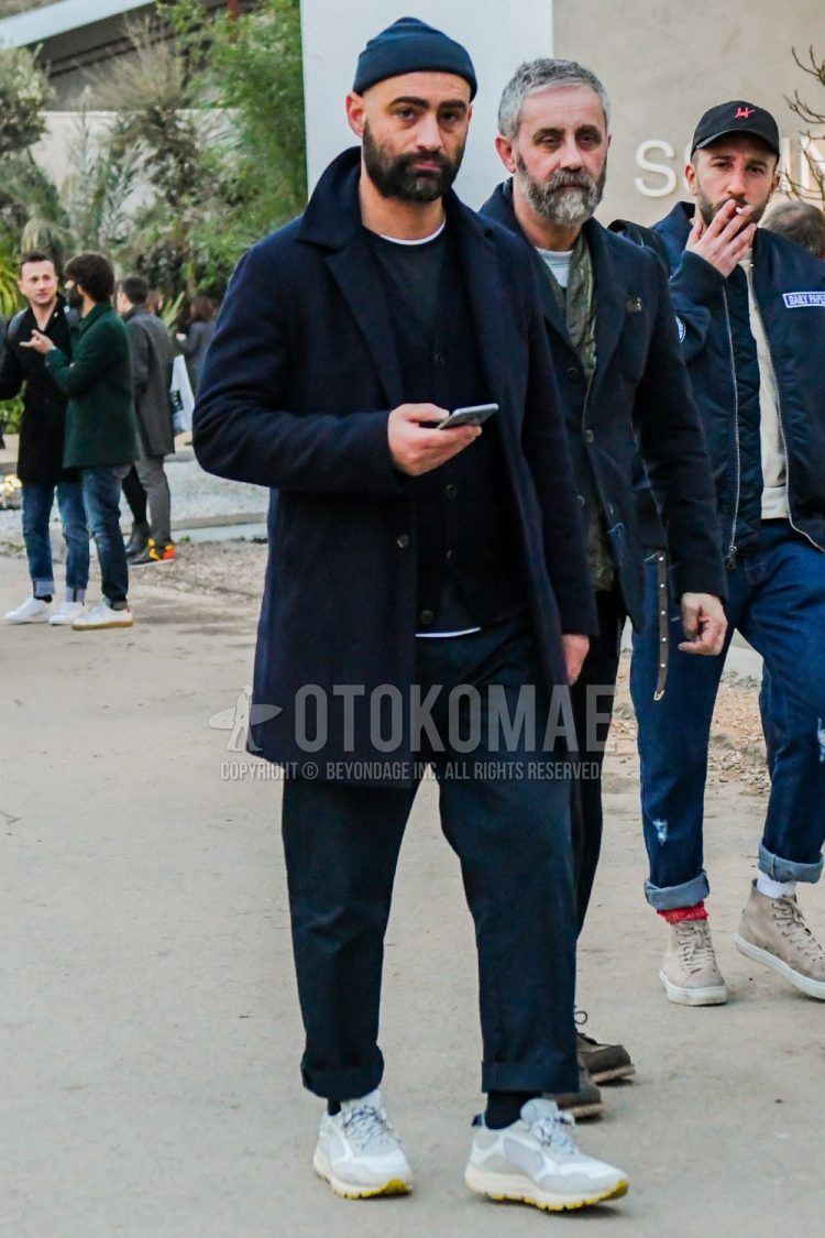 Men's winter/fall outfit with plain navy knit cap, plain navy stainless steel collar coat, plain navy cardigan, plain black t-shirt, plain gray slacks, plain black socks, and white low-cut sneakers.