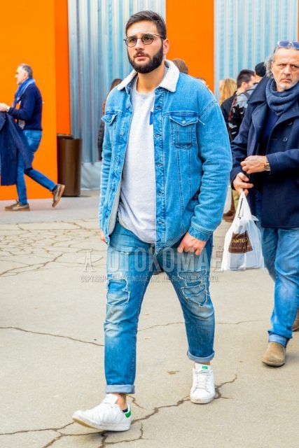 Men's coordinate and outfit with plain glasses, plain blue denim jacket, plain gray sweatshirt, plain blue damaged jeans, and Adidas Stan Smith white low-cut sneakers.