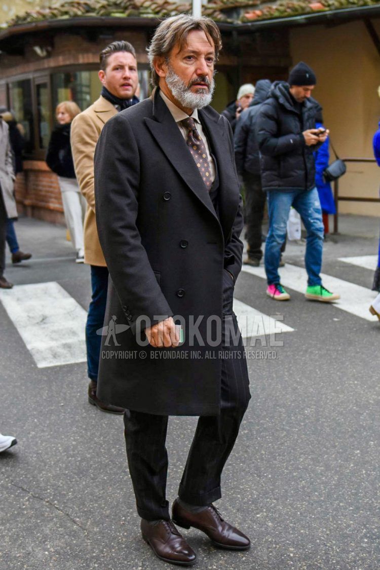 Men's coordinate and outfit with plain black chester coat, plain brown shirt, brown plain toe leather shoes, black striped suit, and brown dot tie.