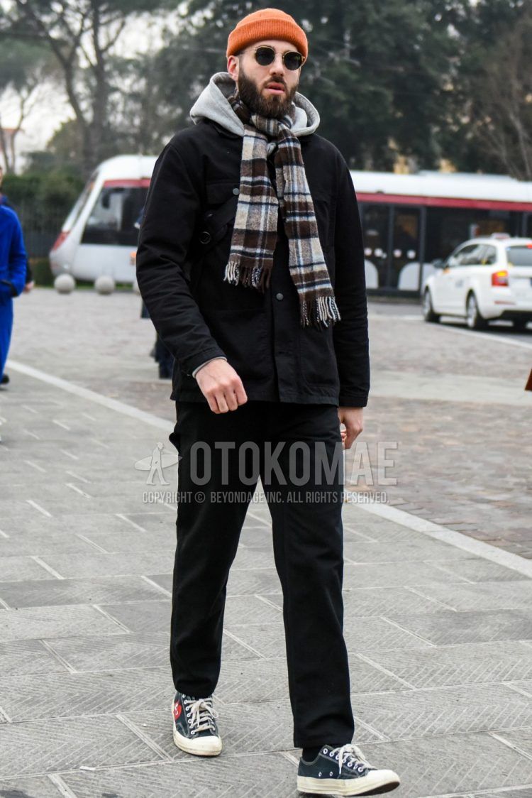 Men's coordinate and outfit with plain sunglasses, brown check scarf/stall, plain black outerwear, plain gray hoodie, plain black cotton pants, and black low-cut sneakers by Comme des Garcons.