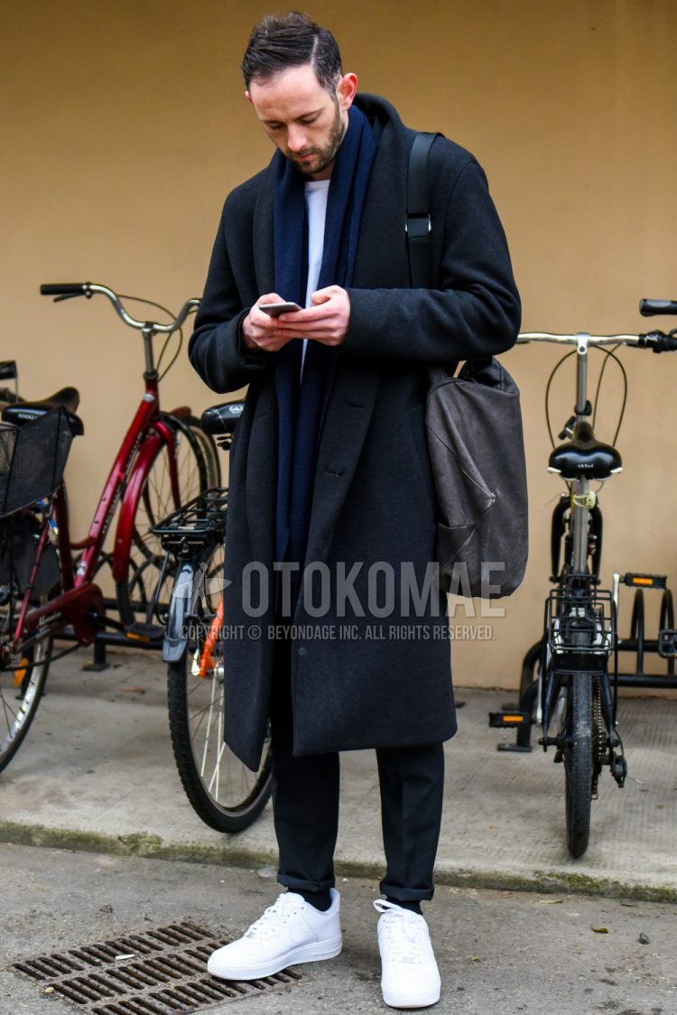 Men's coordinate and outfit with plain navy scarf, plain gray outerwear, plain white t-shirt, plain gray slacks, plain black socks, Nike Air Force 1 white low-cut sneakers, and plain beige shoulder bag.