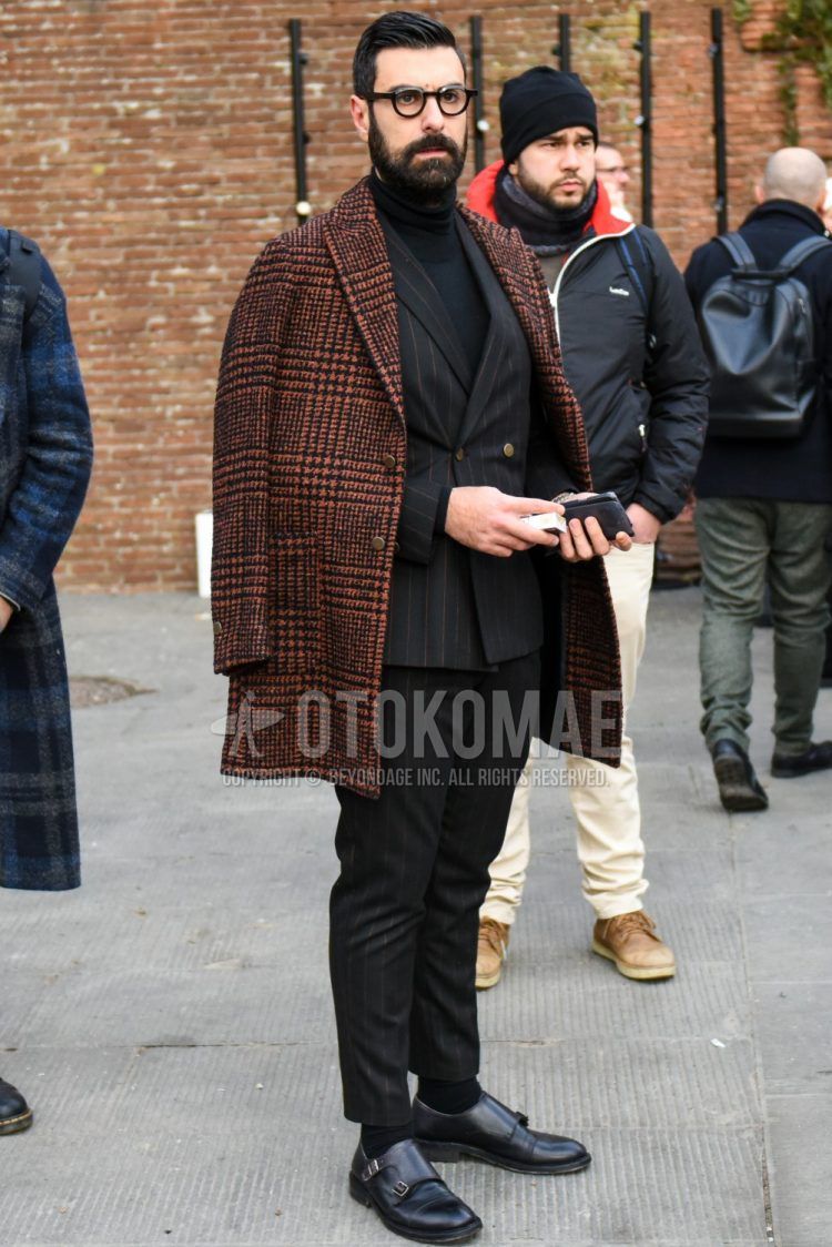 Men's coordinate and outfit with plain glasses, black/orange check chester coat, plain black turtleneck knit, plain black socks, black monk shoe leather shoes, and black striped suit.