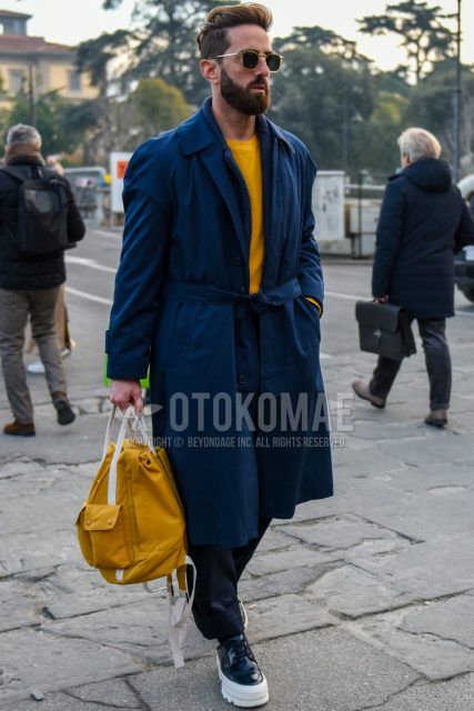 Men's coordinate and outfit with plain sunglasses, plain navy stainless steel collar coat, plain yellow sweatshirt, plain gray slacks, and black low-cut sneakers.