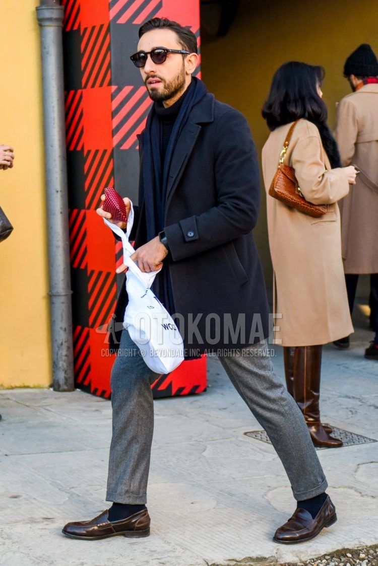 Men's coordinate and outfit with plain black sunglasses, plain navy scarf/stall, plain navy stainless steel coat, plain black turtleneck knit, plain gray slacks, plain navy socks, and brown coin loafer leather shoes in Boston.