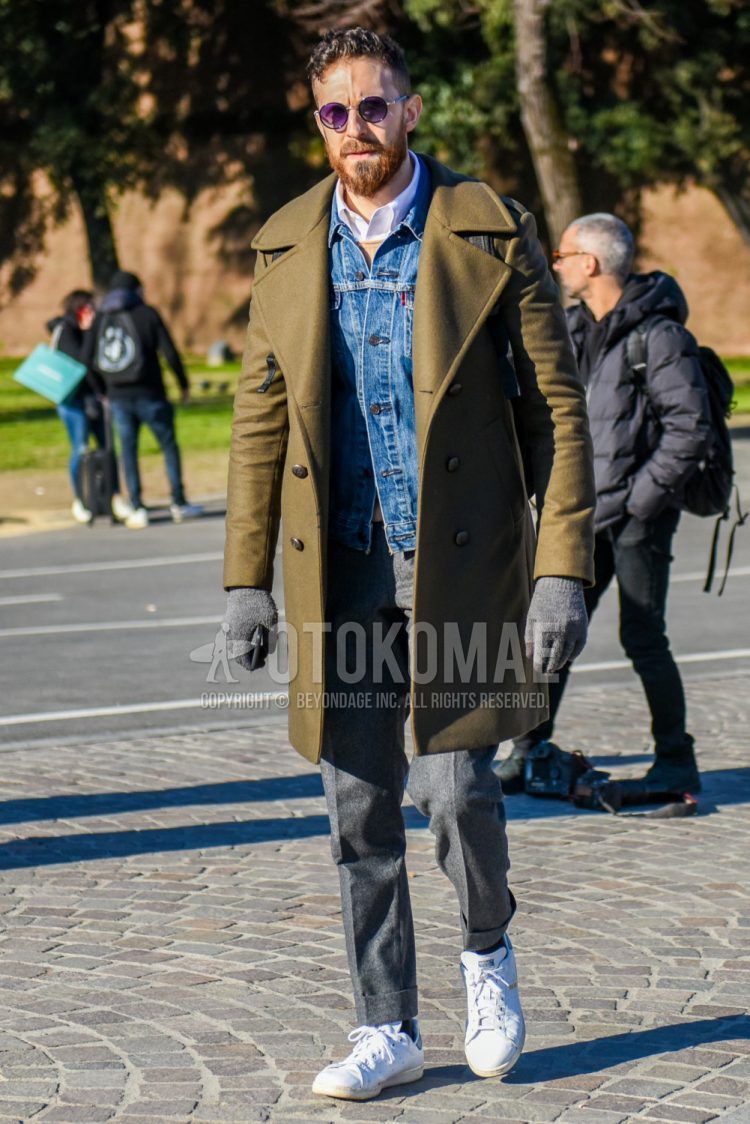 Men's coordinate and outfit with solid black sunglasses, solid beige Ulster coat, solid blue denim jacket, solid white shirt, solid beige sweater, solid gray slacks, solid black socks, and Adidas Stan Smith white low-cut sneakers.