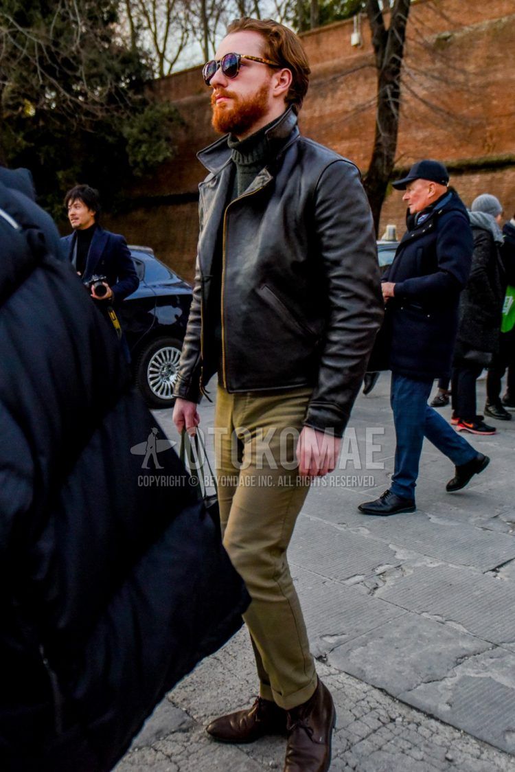 Men's coordinate and outfit with solid color sunglasses, solid color black leather jacket (not riders), dark gray solid color turtleneck knit, solid color brown cotton pants, and brown boots.