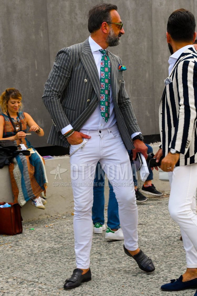 Men's coordinate and outfit with plain sunglasses, gray striped tailored jacket, plain white shirt, plain white denim/jeans, gray loafer leather shoes, and green tie tie.