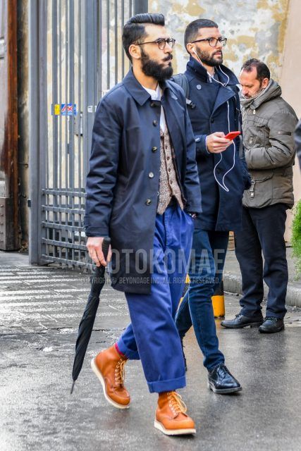 Men's coordinate and outfit with plain glasses, plain black stainless steel collar coat, plain beige gilet, plain white shirt, plain blue cotton pants, and brown work boots.