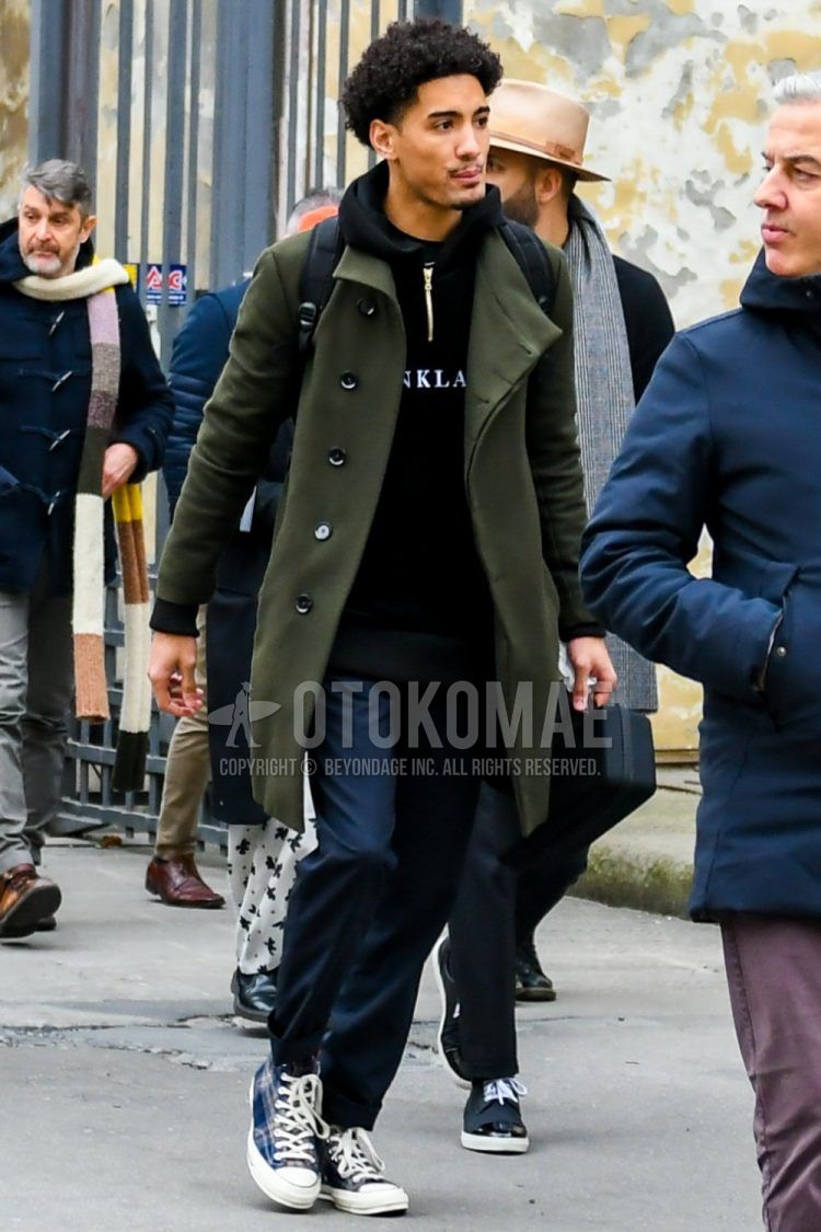 Men's coordinate and outfit with olive green solid color stainless steel collar coat, black graphic hoodie, navy solid color slacks, and navy high-cut sneakers.
