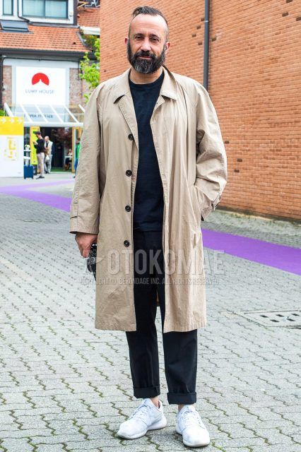 Men's fall/winter coordinate and outfit with plain beige stainless steel collar coat, plain black t-shirt, dark gray plain slacks, and white low-cut sneakers.