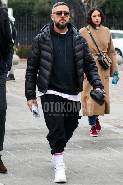 Winter men's coordinate and outfit with solid color sunglasses, solid color black down jacket, solid color black hoodie, solid color white t-shirt, solid color black slacks, solid color white socks, solid color white high-cut Air Jordan sneakers, solid color black clutch bag/second bag/drawstring.