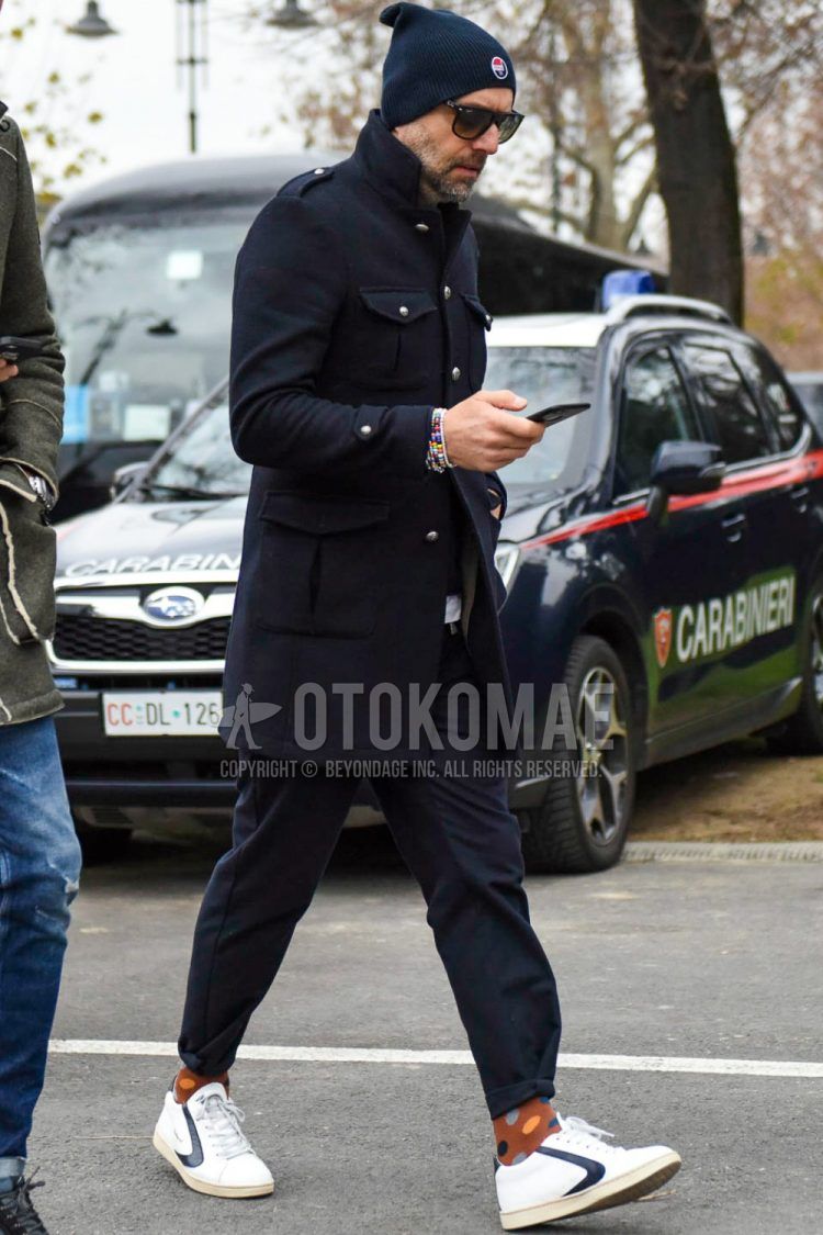 Men's coordinate and outfit with navy decal logo knit cap, plain navy M-65, plain navy slacks, brown dot socks, and white low-cut sneakers by Val Sport.