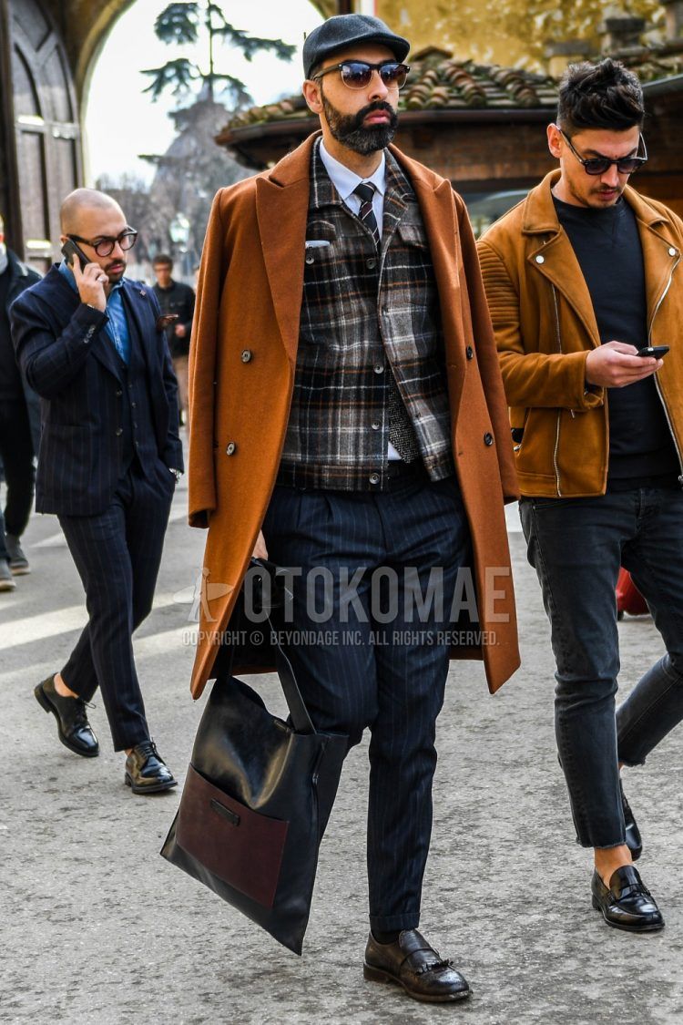 Men's coordinate and outfit with plain baseball cap, plain sunglasses, plain brown chester coat, brown checked trucker jacket, plain white shirt, black striped slacks, plain black socks, brown loafer leather shoes, and plain black tote bag.