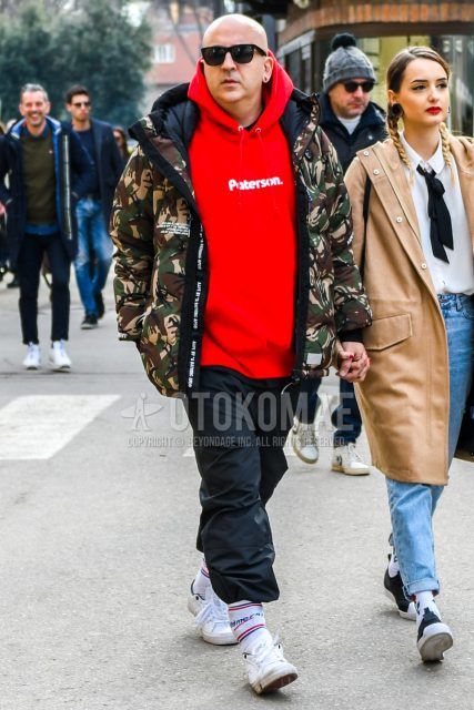 Men's coordinate and outfit with solid color sunglasses, multi-colored camouflage down jacket, solid red hoodie, solid black wide-leg pants, solid white socks, and white low-cut sneakers.