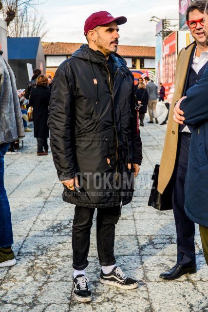 Men's coordinate and outfit with solid color baseball cap, solid color black hooded coat, solid color black denim/jeans, solid color white socks, and Vans Old School black low-cut sneakers.