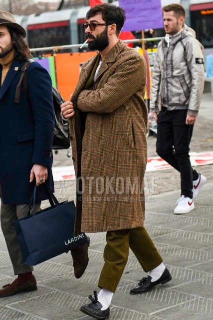 Men's coordinate and outfit with plain sunglasses, brown check chester coat, plain white socks, black tassel loafer leather shoes, and plain olive green suit.