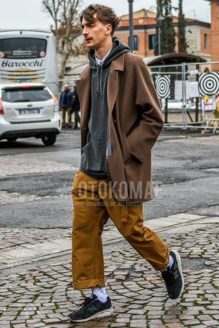 Men's winter/autumn coordinate and outfit with Burberry plain brown stainless steel coat, plain gray hoodie, plain white shirt, plain brown wide pants, plain brown chinos, Acoldwall white decal logo socks, and New Balance black low-cut sneakers.