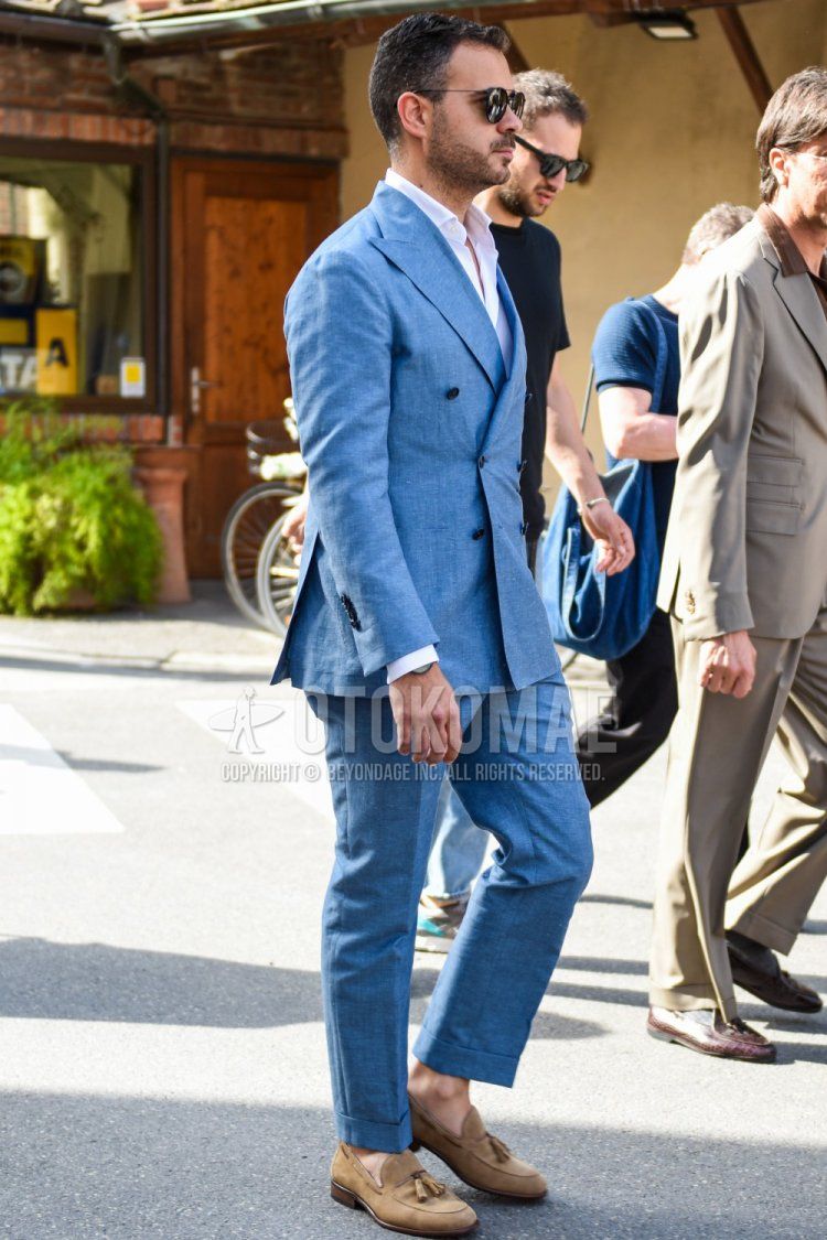 Men's coordinate and outfit with plain black sunglasses, plain white shirt, suede brown tassel loafer leather shoes, and plain blue suit.