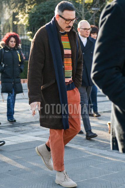 Men's fall/winter coordinate with brown tortoiseshell glasses, solid gray scarf/stall, solid brown chester coat, sweater with multi-colored stripes, solid orange cropped pants, solid orange winter pants (corduroy, velour), Clarks gray boots. Outfit.